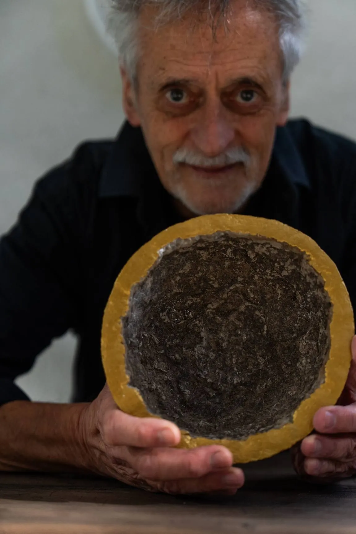 Retrato de Guillo D Aiello sosteniendo una pieza con hoja de oro