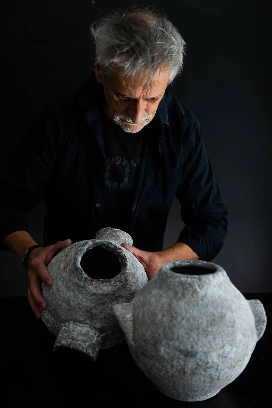 El artista junto a dos vasijas grandes