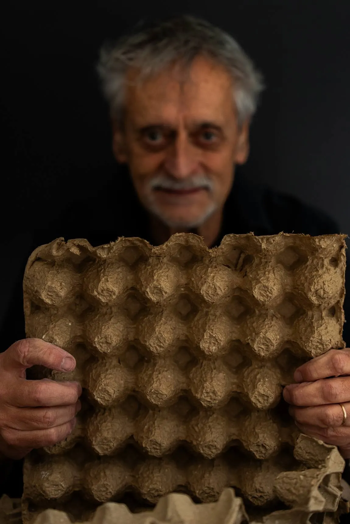 El artista sosteniendo un maple de carton de huevos